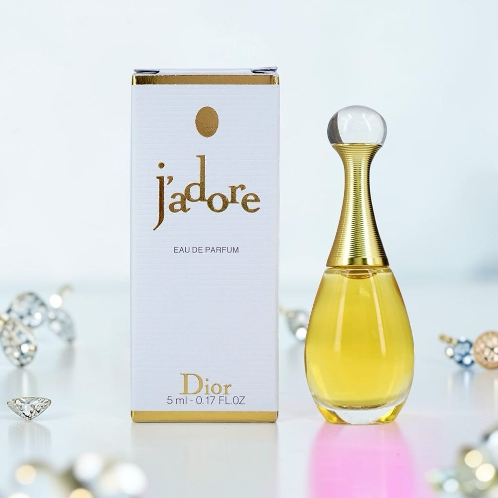 Nevora Dior J'adore miniature eau de parfum bottle with its signature amphora shape next to the white and gold box.
