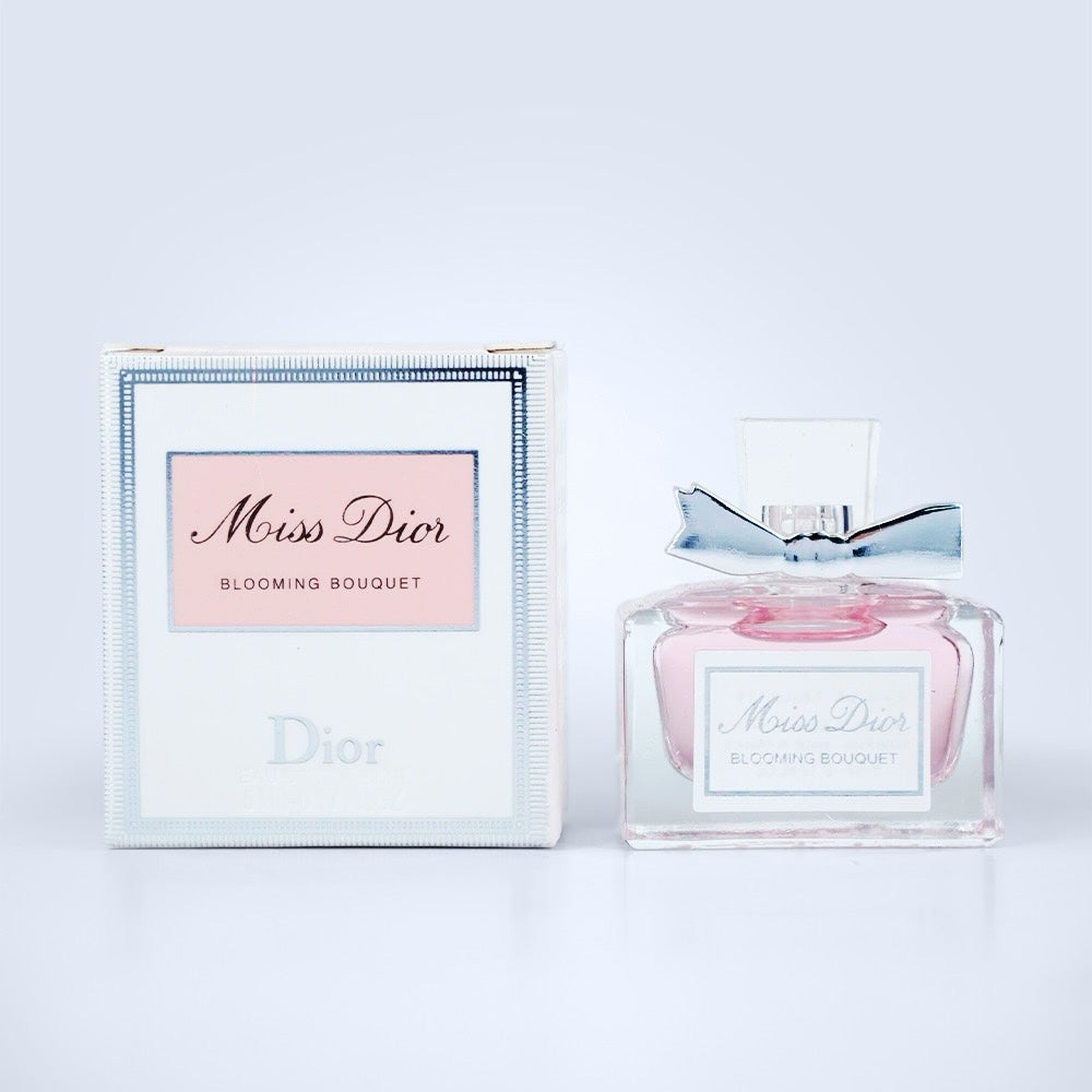 Nevora Miss Dior Blooming Bouquet Eau de Toilette in a glass bottle with a silver bow next to its elegant gift box.